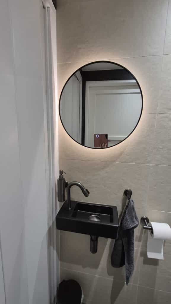 Badkamerspiegel Ilona 50×50, met zwarte lijst boven toilet fontein impressie 2