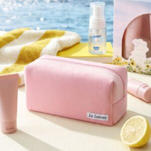 Roze La Lunore Bubblegum toilettas op een tafel bij het water met zonnebrandcrème en citroen